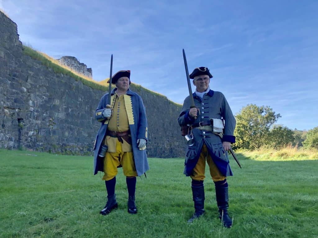historiskt klädda män utanför muren vid vigsel på bohus fästning